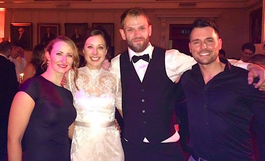 A bride and groom celebrating with members of House Party